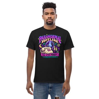 Black unisex T-shirt with a neon Paranormal Hotline graphic, telephone, ghostly crystal ball and Call After Midnight lettering, front view, worn by a model